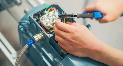 Electrical Engineering student fixes motor in laboratory at LUT campus.