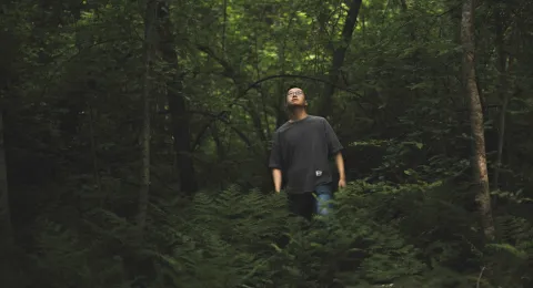 LUT University student in a forest watching the sky