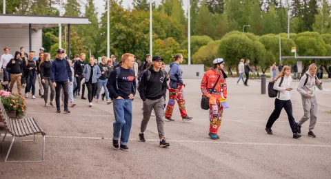 Opiskelijoita kävelemässä yliopiston pihalla.