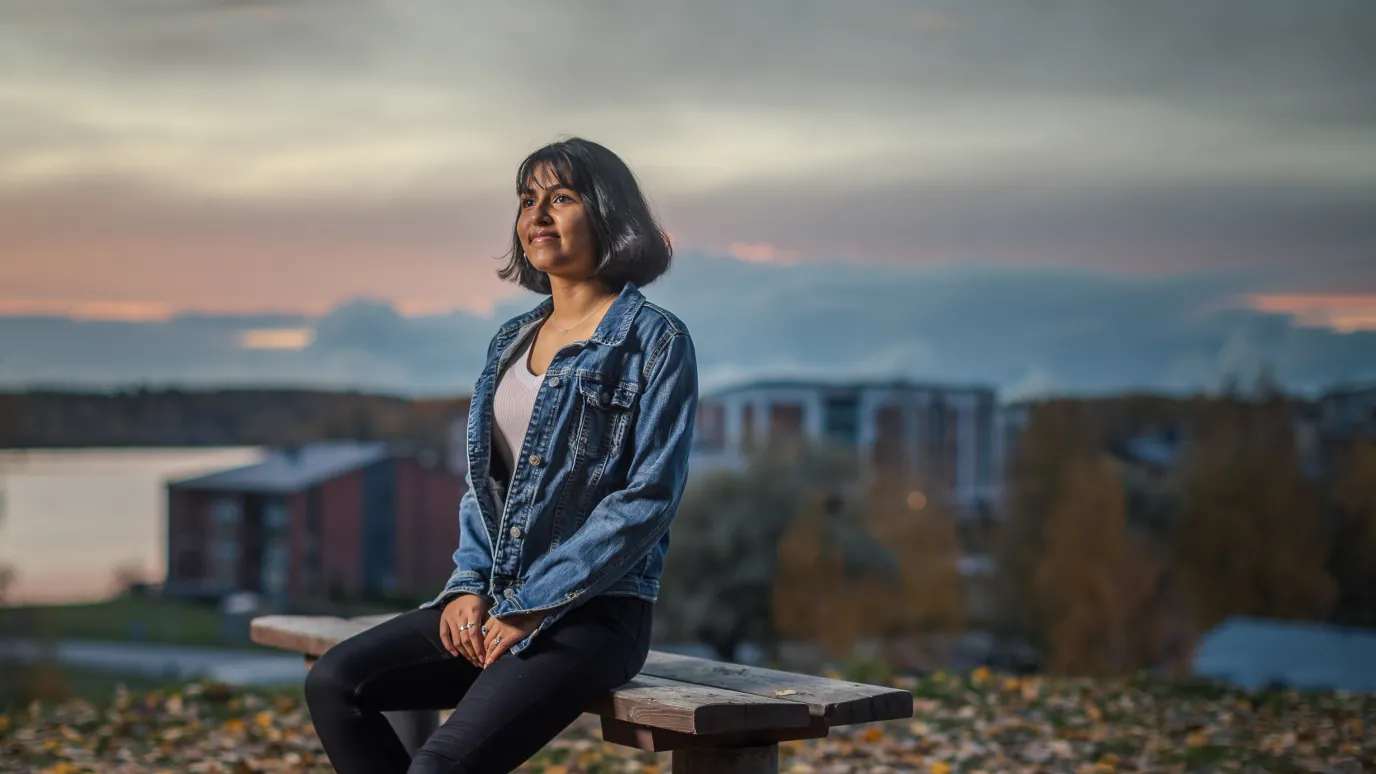 LUT University student sitting on a bench in a urban fall scenery