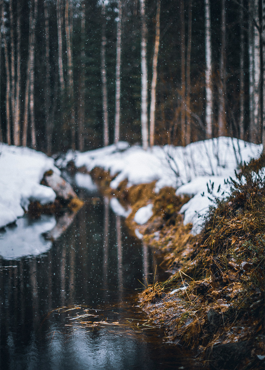 Stream flowing through snowy scenery